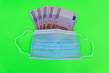 Virüs koruması için mavi maske ve 500 Euro. Sağlık ve para konsepti, covid-19