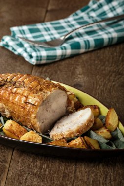 Ahşap bir masada fırında patates ve adaçayı ile kızartılmış tavuk.. 