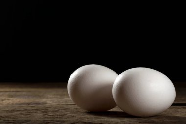Tahta bir masada iki taze beyaz yumurta..