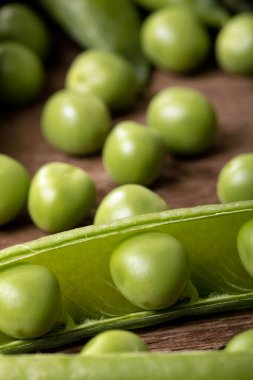 Tahta masadaki taze toplanmış bezelyeleri yakın plan çek..