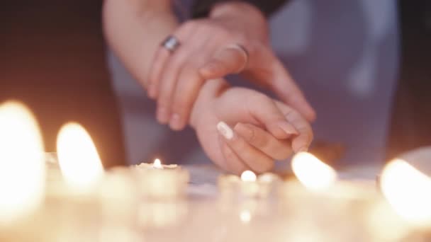 Mano del hombre acaricia suavemente la mano de una mujer a la luz de las velas, toque la mano — Vídeos de Stock