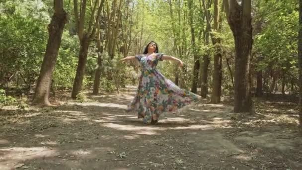 Mooie vrouw loopt langs een bospad en dansen, zomertuin — Stockvideo