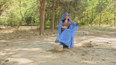 Etnik mavi elbiseli güzel Arap tarzı, etnik müzik aleti çalıyor.