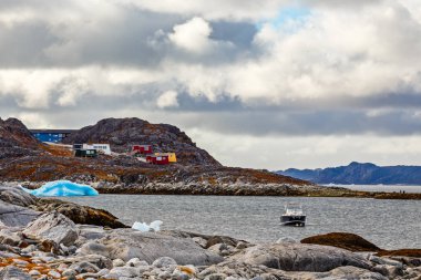 Taş kutup sahil, motorbot ve mavi arka plan, Nuuk, Grönland buzlu küçük renkli evlerin yuvasındaki yüzen buzdağı