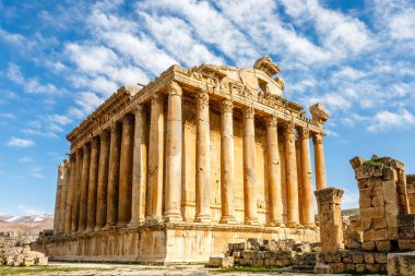 Ancient Roman temple of Bacchus with surrounding ruins with blue clipart