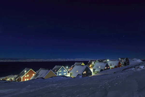 Casas inuit amarillas, azules, rojas y verdes cubiertas de nieve en el —  Fotos de Stock