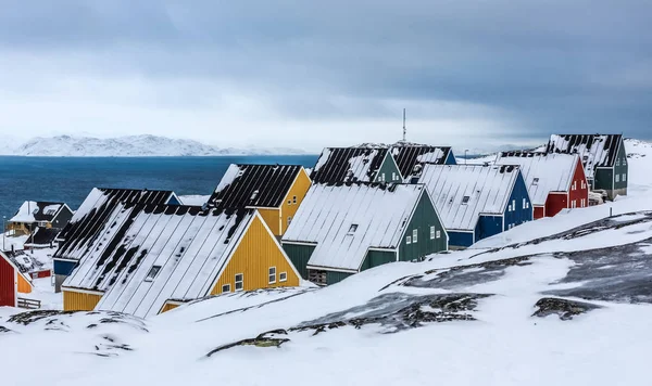 Jaune, bleu, rouge et vert maisons inuit recouvertes de neige à la — Photo