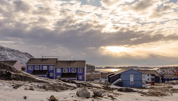 Polární západ slunce nad domy Inuit na skalnatých kopcích se sněhem, Nuu — Stock fotografie