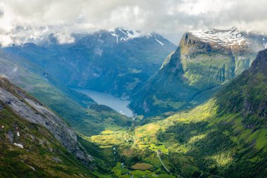 Moun ile çevrili yeşil vadi ile Geiranger fiyort görünümü
