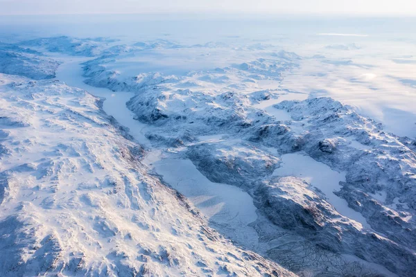 Greenlandic ice cap with frozen mountains and fjord aerial view,