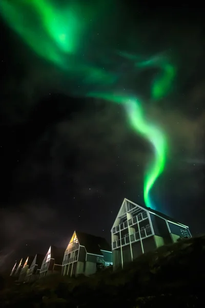 Grüne, helle Nordlichter, die teilweise von den Wolken über — Stockfoto