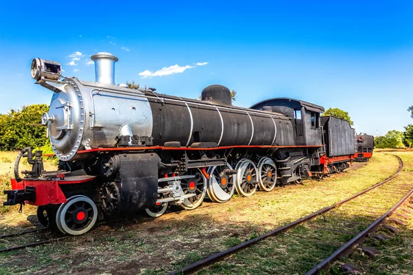 Alte Retro-Lokomotive aus Stahl, die im Wohnzimmer auf den Schienen steht — Stockfoto