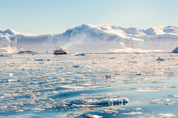 Kırmızı buharlı gemi, buzdağlarının arasında sürükleniyor. — Stok fotoğraf
