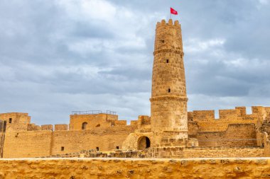 Ribat Manastırı 'nın tepesinde Tunus bayrağı olan iç bahçeler ve gözetleme kulesi bulutlu gökyüzünün altında, Manastır, Manastır, Tunus Valiliği,