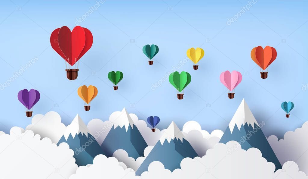 Origami made hot air balloon in a heart shape float over the mountain, paper art 3d from digital craft.