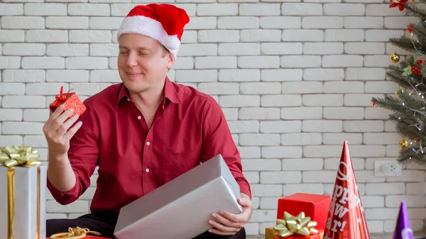 Junger Kaukasischer Mann Mit Geschenkbox Der Neben Dem Weihnachtsbaum Sitzt — Stockfoto