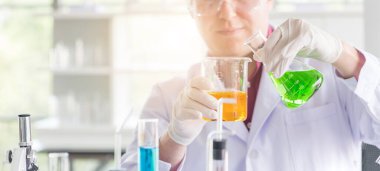 Bilim laboratuarında araştırma yaparken deney tüpüyle test yapan genç beyaz bilim adamları. 