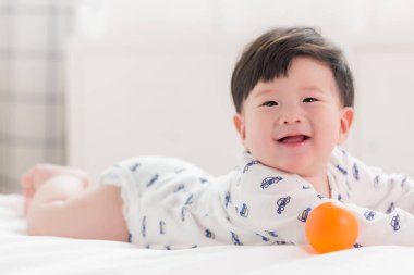 Oyuncak ve tatlı gülen yüzlü Asyalı sevimli bebek..