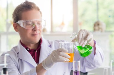 Bilim laboratuarında araştırma yaparken deney tüpüyle test yapan genç beyaz bilim adamları. 