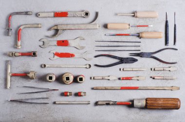 Profesyonel tamirci için gri beton arka planda bir takım eski araçlar