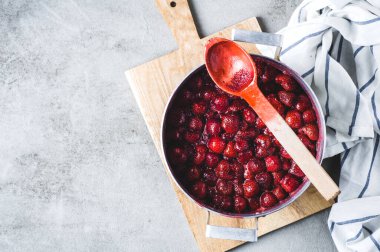 Gri beton arka planda alüminyum bir tavada ev yapımı çilek reçeli