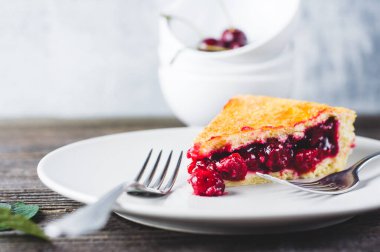 Koyu ahşap bir masada kirazlı turta ve taze böğürtlen