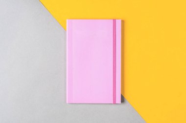 Gri-sarı arkaplanda pembe not defteri