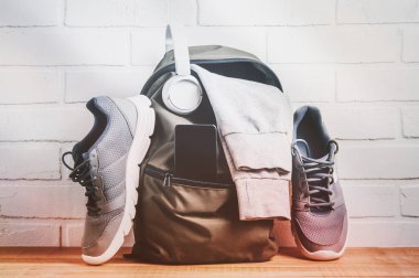 Spor giyimli ve spor ayakkabılı yeşil sırt çantası. Fitness veya çalışma konsepti