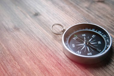 Koyu tahta arka planda eski bir pusula. Metin veya tasarım için boşluk kopyala