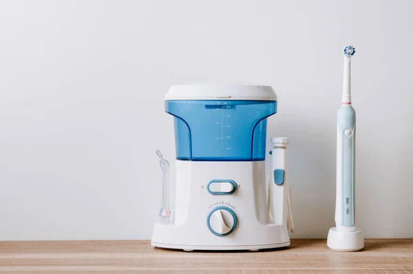Işık arka planında sulayıcı ve elektrikli diş fırçası