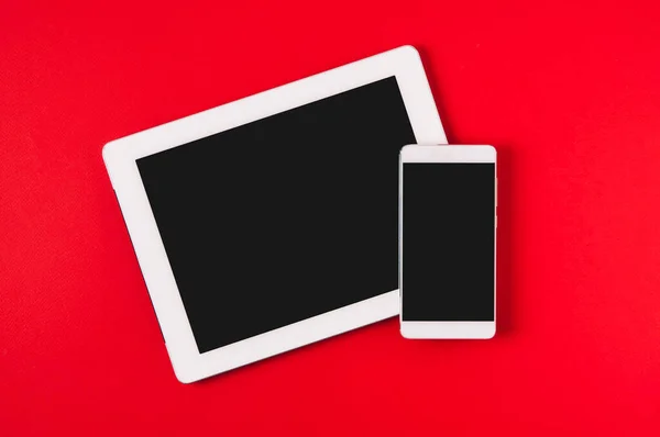 Kırmızı arka planda cep telefonu ve tablet. Metin ya da uygulama tasarımı için şablon