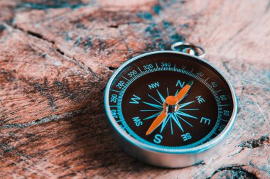 Koyu tahta arka planda eski bir pusula. Metin veya tasarım için boşluk kopyala