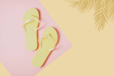 Pembe-sarı arka planda sarı parmak arası terlikler. Metin veya tasarım için boşluk