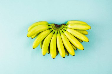 Turkuaz arka planda izole edilmiş muz. Düz yatış ve üst görünüm