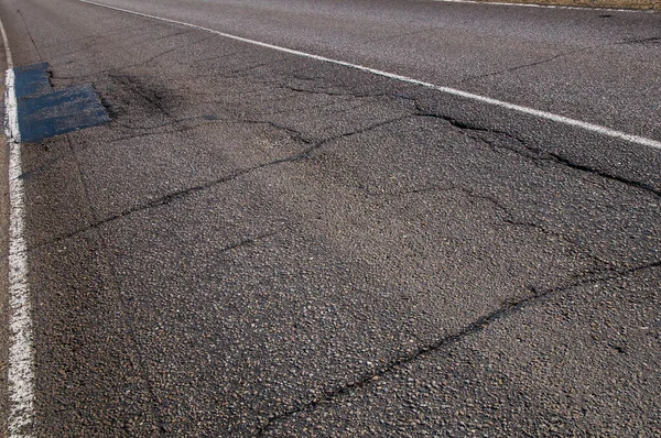 Old asphalt road with cracks