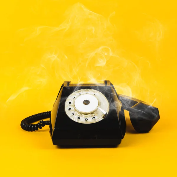 Sarı arka planda eski telefon ve duman