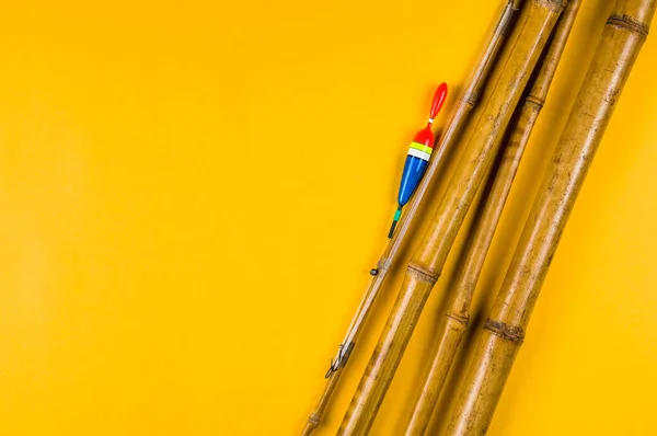 Sarı arka planda eski bir bambu oltası