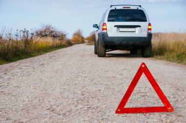 Kırsal yoldaki acil durum dur işareti ve kırık gümüş güneş arabası