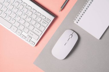 Soluk gri-pembe arkaplanda klavye ve fare