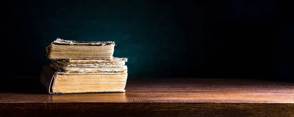 Ahşap arka planda bir yığın eski kitap. Metin veya tasarım için boşluk
