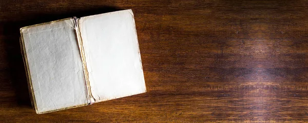 Ahşap arka planda açık eski bir kitap. Metin veya tasarım için boşluk