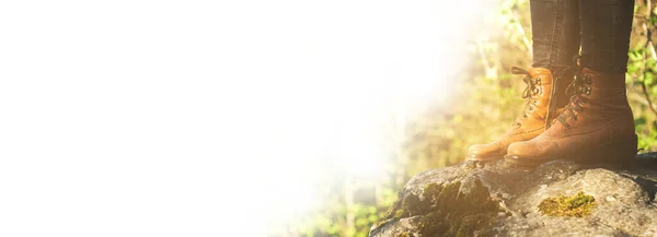 Orman arka planında yürüyüş ayakkabısı giymiş kadın bacaklar. Metin veya tasarım için boşluğu kopyala