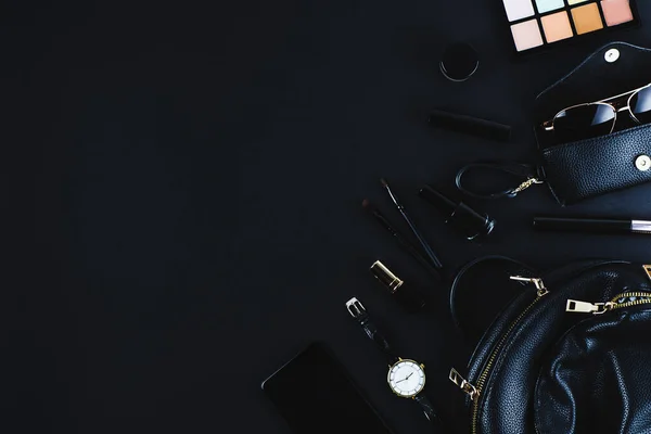 Siyah arka planda siyah kadın çantası ve aksesuarları. Düz konum ve üst görünüm, metin veya tasarım için boşluk kopyala