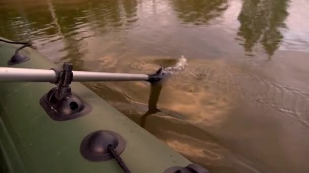 パドルは湖の膨脹可能なボートに乗る間に水に下げられます。 — ストック動画