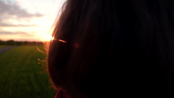 Une jeune fille photographie un coucher de soleil à la campagne — Video