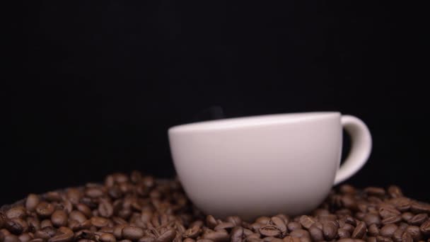 커피 원두 위에 서 있는 하얀 커피 잔의 증기 — 비디오
