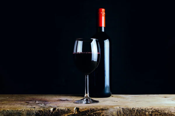 Ein Glas Rotwein Und Eine Flasche Auf Einem Alten Holztisch — Stockfoto