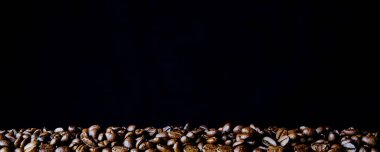 Parlak sarı arka planda kahve çekirdekleri. Metin ve panoramik çerçeve için boşluk kopyala