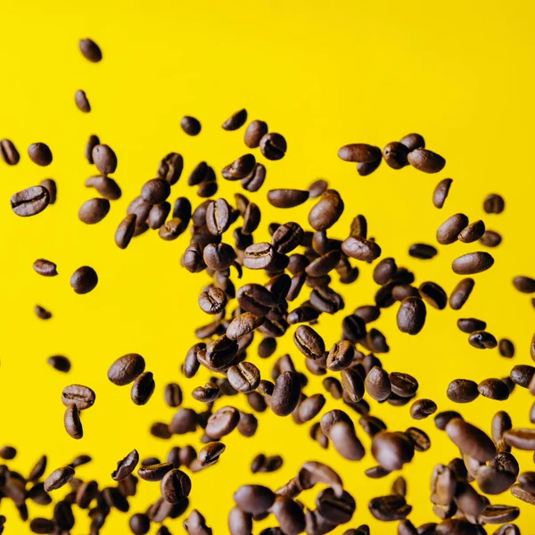 Parlak sarı arka planda uçan kahve çekirdekleri.