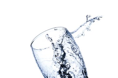 Beyaz arka planda izole edilmiş şeffaf bir bardağa su sıçrıyor.